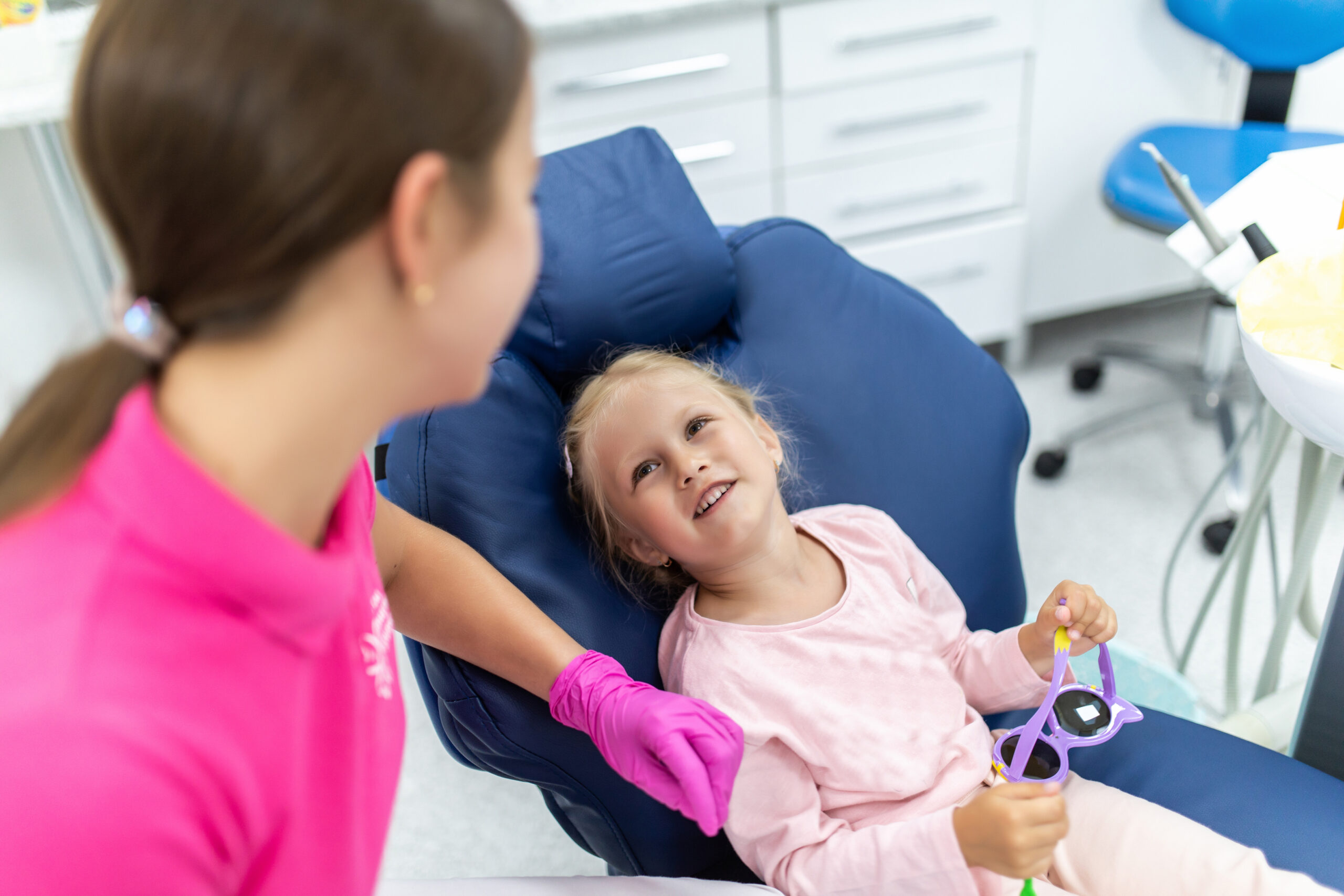 Cheerful pediatric dentist with a smiling young patient