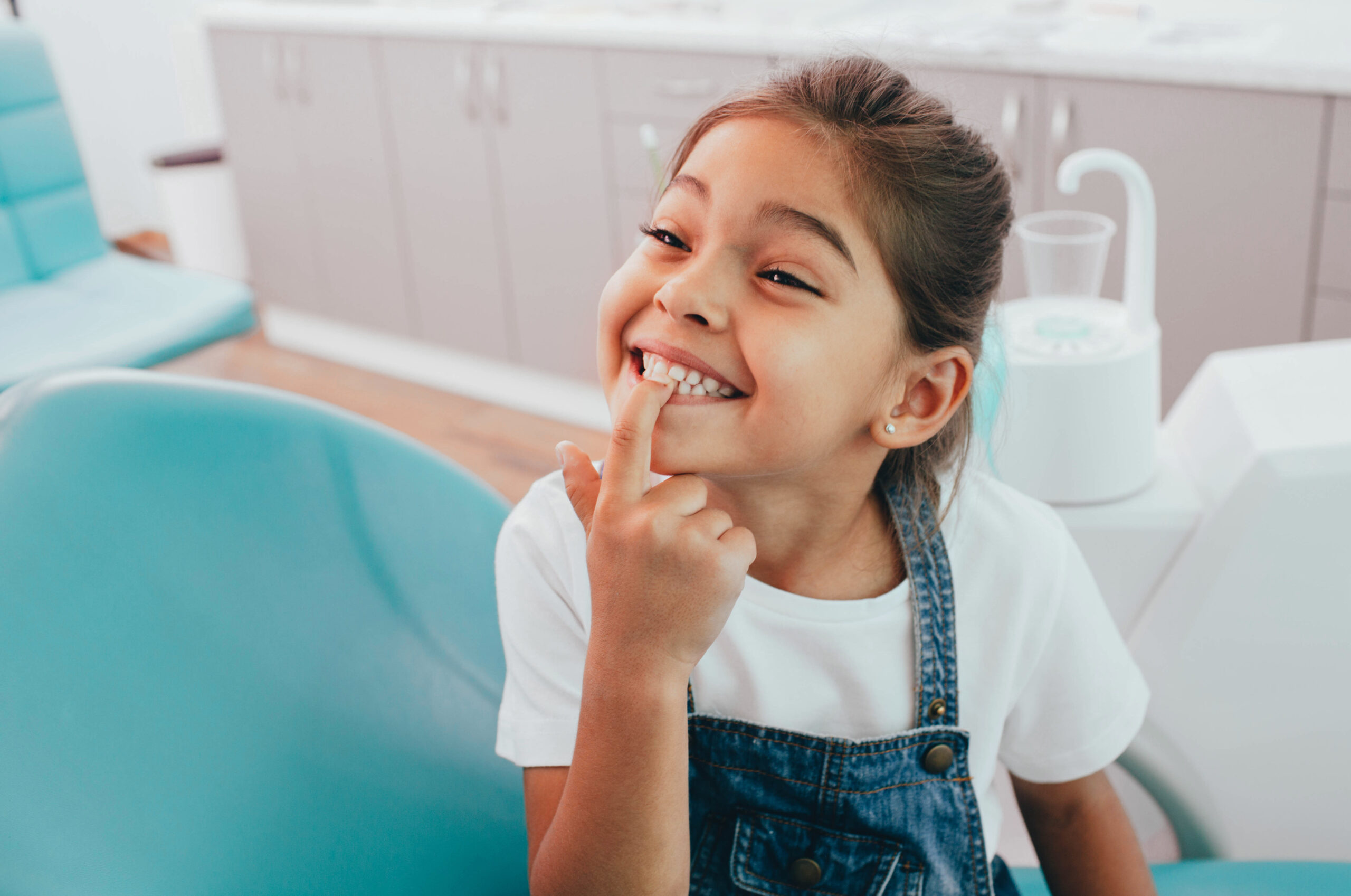 Young patient showing a bright toothy smile in the dental chair