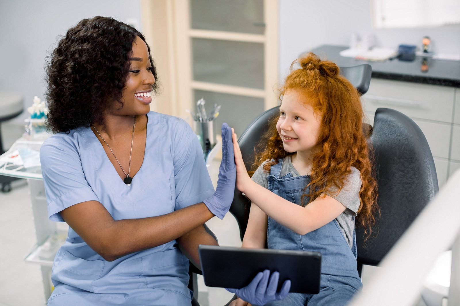 Pediatric dentist performing gentle pulp therapy on a young patient