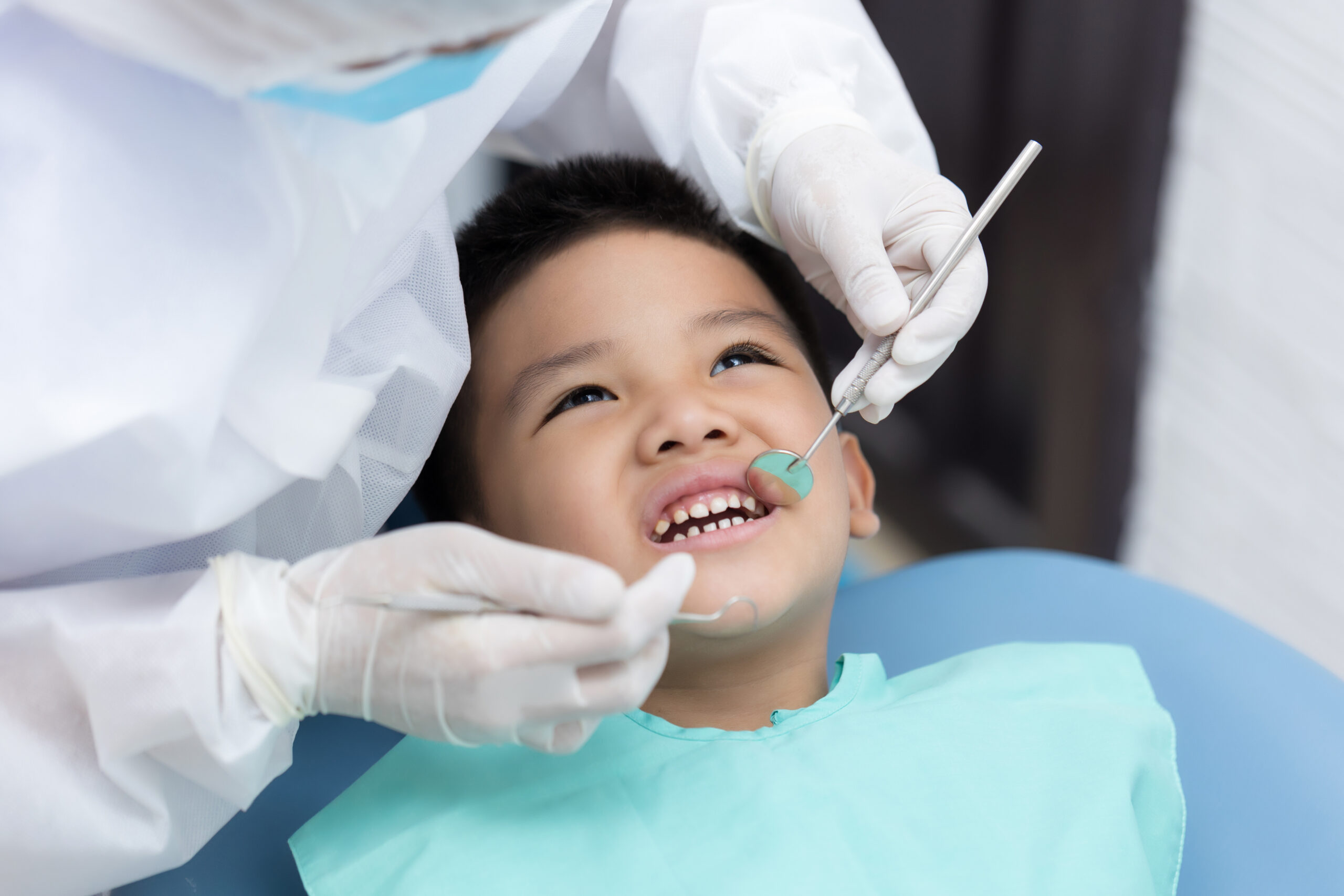 Dentist examining a young boy's teeth in a clinic