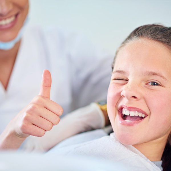 Dentist, child and portrait with thumbs up with teeth cleaning or cavity treatment for oral hygiene, healthy or whitening. Female person, face and hand gesture for happy consultation, dental or yes.